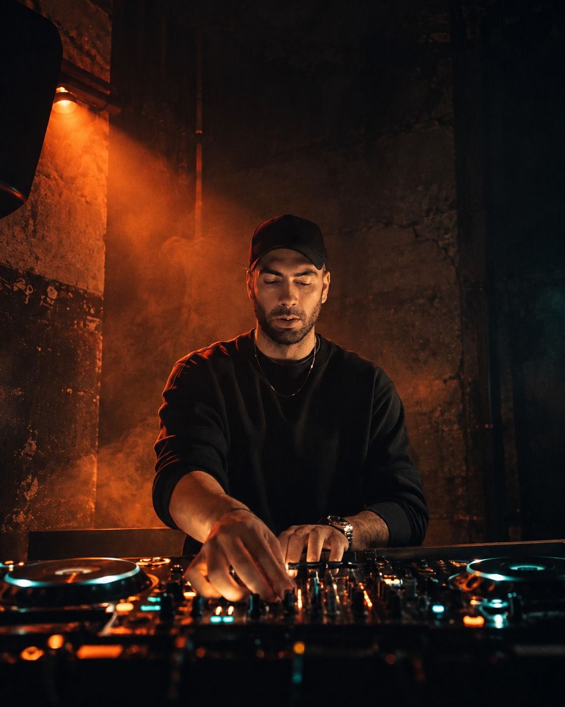 RodMeister playing a DJ set, hands on the mixer, in a dark club